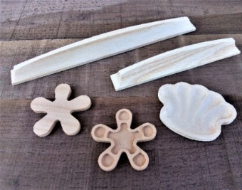 Maniglie, fregi, un fiore e una conchiglia in legno massello su un banco